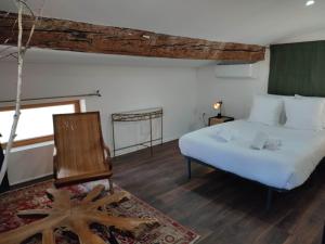 1 dormitorio con 1 cama y 1 silla en La Terrasse du Temps Jadis ConcirgerieDameCarcas en Carcasona