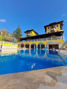 een groot zwembad met een gebouw op de achtergrond bij Altinsaray Hotel in Kuşadası