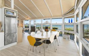 een keuken en eetkamer met een tafel en stoelen bij Nice Home In Haderslev With House Sea View in Hejlsminde