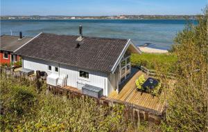 una casa en una terraza con vistas al agua en Nice Home In Haderslev With House Sea View, en Hejlsminde