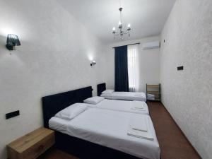 a bedroom with two beds and a chandelier at Soma in Kutaisi