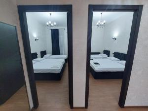 two mirrors in a room with two beds at Soma in Kutaisi