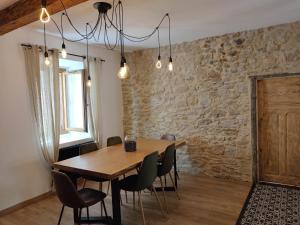 a dining room with a wooden table and chairs at La Terrasse du Temps Jadis ConcirgerieDameCarcas in Carcassonne