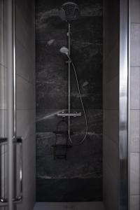 una doccia in bagno con parete nera di Le Clos De L'étang Jura a Frasne