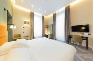 Pokój hotelowy z dużym białym łóżkiem i biurkiem w obiekcie Hotel Astoria w Genui