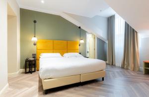 a bedroom with a large bed with a yellow headboard at Hotel Astoria in Genova