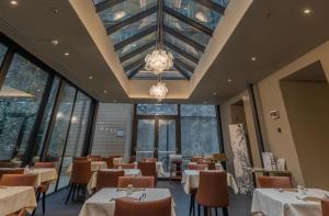 restauracja ze stołami i krzesłami oraz żyrandolem w obiekcie Hotel Astoria w Genui