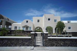 una gran casa blanca con un muro de piedra en Mikro Petrino, en Vóthon
