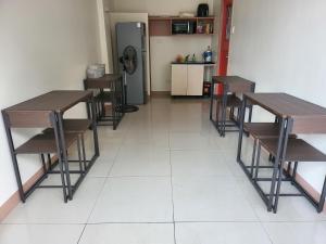 a room with tables and chairs and a kitchen at Dormitory near SM and S and R in Davao City