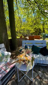 ein Tisch mit einem Blumenarrangement auf einer Bank in der Unterkunft Pod Platanem Gliwice in Gliwice