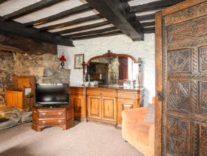 a living room with a tv and a wooden door at Gilfachwydd in Dolgellau