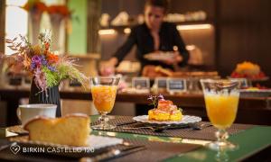 a table with a plate of food and two glasses of orange juice at Albergo Diffuso Birkin Castello in Cagliari