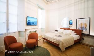 a bedroom with a bed and two chairs at Albergo Diffuso Birkin Castello in Cagliari