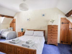 a bedroom with a bed and a dresser with towels on it at Gilfachwydd in Dolgellau