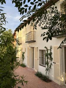 a white building with a balcony and a walkway at Casa Josephine Riofrío - retiro a 1 h de Madrid in La Losa