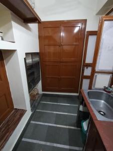 a small kitchen with a sink and a wooden cabinet at HERITAGE HOMESTAY@OLD CITY NEAR GANGES in Varanasi