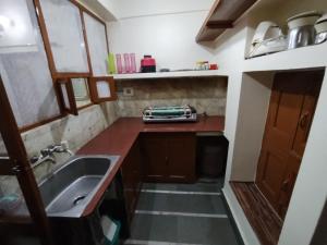 Il comprend une petite cuisine avec un évier et un comptoir. dans l'établissement HERITAGE HOMESTAY@OLD CITY NEAR GANGES, à Varanasi