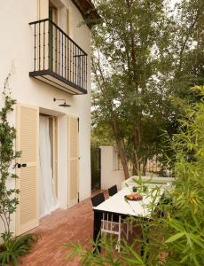 um pátio com uma mesa e cadeiras e uma varanda em Casa Josephine Riofrío - retiro a 1 h de Madrid em La Losa