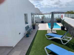 balkon z leżakami i basenem w obiekcie Villa Stella Maris w mieście Playa Blanca