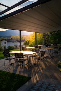 a patio with tables and chairs under a canopy at Garnì Tuttotondo in Levico Terme