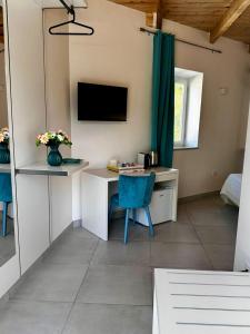 Zimmer mit einem Schreibtisch und einem TV an der Wand in der Unterkunft Dimora Schiappone in Ischia