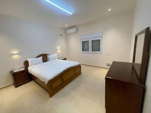 a bedroom with a bed and a flat screen tv at Oak Farm مزرعة البلوط in Ajloun