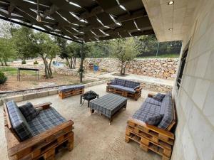 an outdoor patio with couches and a table and benches at Oak Farm مزرعة البلوط in Ajloun