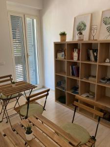 um quarto com uma mesa e cadeiras e uma estante de livros em A Suata em Maratea