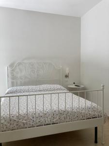 a white bedroom with a white bed and a white wall at A Suata in Maratea