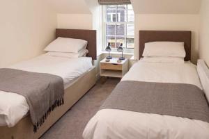 a bedroom with two beds and a window at Stroan in New Galloway