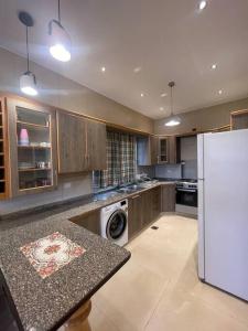 a kitchen with a refrigerator and a washer and dryer at Oak Farm مزرعة البلوط in Ajloun
