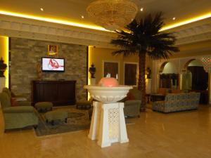 a lobby with a palm tree and a large fountain at Sharjah International Airport Hotel in Sharjah