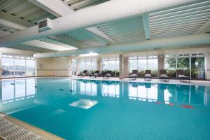 a large indoor swimming pool with blue water at Macdonald Cardrona Hotel, Golf & Spa in Peebles