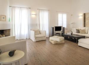 salon z białymi meblami i telewizorem w obiekcie Villa Island , Luxury Villa in Mykonos w mieście Agia Anna