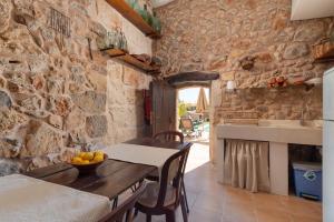 uma cozinha com uma mesa e uma parede de pedra em Casa del Sol em Búger