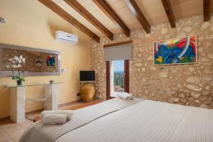 um quarto com uma cama grande e uma parede de pedra em Casa del Sol em Búger