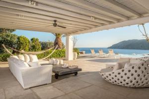 patio z białymi krzesłami, hamakiem i oceanem w obiekcie Villa Island , Luxury Villa in Mykonos w mieście Agia Anna