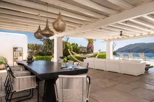 - patio z czarnym stołem i krzesłami w obiekcie Villa Island , Luxury Villa in Mykonos w mieście Agia Anna