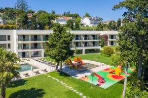 an apartment building with a playground and a pool at Vila Gale Collection Palácio dos Arcos in Oeiras