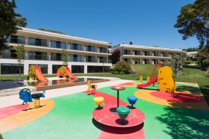 een school met een speeltuin met glijbanen en een gebouw bij Vila Gale Collection Palácio dos Arcos in Oeiras