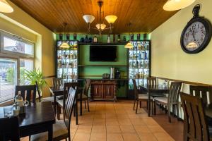 a restaurant with tables and chairs and a clock on the wall at Penzion Rodos - Café in Prague