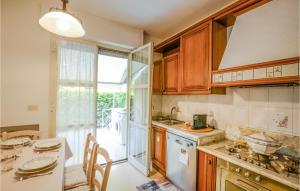 a kitchen with wooden cabinets and a table with chairs at 3 Bedroom Lovely Home In Marina Di Pietrasanta in Marina di Pietrasanta