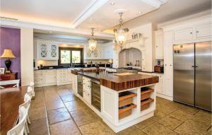 una grande cucina con armadi bianchi e frigorifero in acciaio inossidabile di Cozy Home In Elviria With Wifi a Marbella