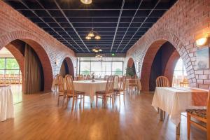 a dining room with tables and chairs and a brick wall at Villa Andropoff in Pärnu