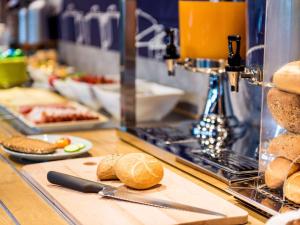 una línea de buffet con pan y comida en una mesa en Ibis Budget Wuppertal Oberbarmen, en Wuppertal