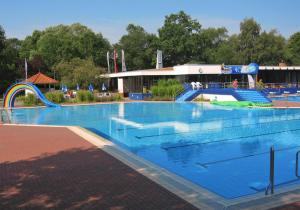 a large swimming pool with a water slide at Heidhöhe, Ferienwohnung in Jesteburg