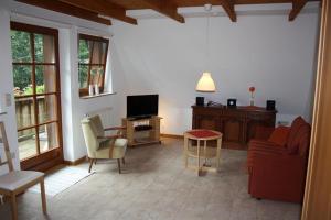 a living room with a couch and a tv at Heidhöhe, Ferienwohnung in Jesteburg