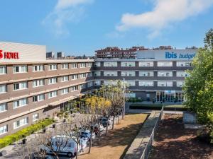 a building with cars parked in front of it at Ibis Budget Barcelona Viladecans in Viladecáns