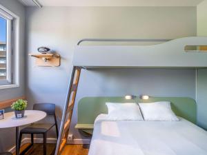 Ibis Budget Barcelona Viladecans في فيلاكانس: غرفة نوم مع سرير بطابقين وطاولة