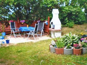 Apartment Kenz-Küstrow في بارث: حديقة خلفية بها طاولة وكراسي ونباتات